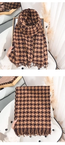 Detailed texture of brown houndstooth scarf with elegant fringes and cashmere-like fabric