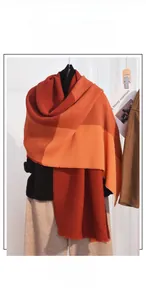 Detail of soft cashmere-like scarf showing orange and brown color block knit texture