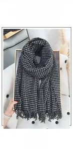 Detailed view of thick houndstooth cashmere scarf with classic black and white fringe trim