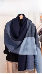 Detail of color-block knit scarf showing blue textured ribbing and waffle weave finish