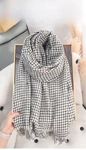 Detail of black and white houndstooth cashmere scarf with delicate fringe tassels