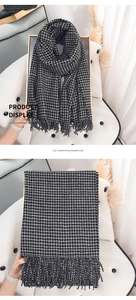 Detail of classic black and white checkered imitation cashmere scarf with tassel edges