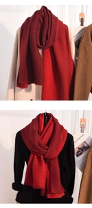 Close-up of thick knitted scarf with deep red color blocking and ribbed texture detail