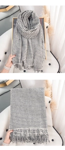 Close-up of black and white checkered scarf with soft fringe edges and woven texture