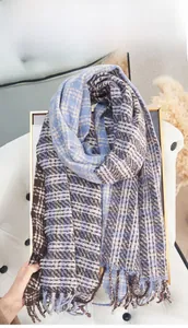 Detail of soft brown and blue checkered scarf showing knit texture and fringe tassels