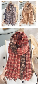 Detail view of plaid cashmere scarf with long tassels in blue, beige, and brown tones