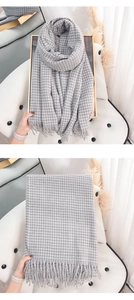 Detailed close-up of gray and white plaid scarf featuring soft fringe and thick cashmere feel