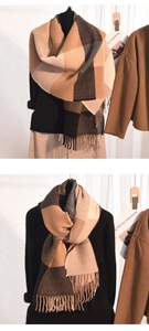 Détail d'une écharpe en maille épaisse avec motif à carreaux et longues franges