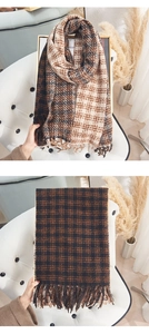 Detail view of winter cashmere-feel plaid scarf showing warm brown fringe and thick texture