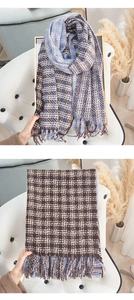 Detail of soft cashmere-feel scarf with blue and brown check pattern and long fringe