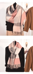 Détail d'une écharpe à carreaux rose et gris avec franges et texture en maille douce