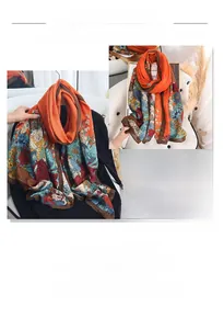 Detail of vibrant orange floral print scarf showing its smooth texture and large size