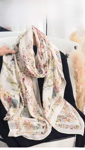 Detailed close-up of a floral print scarf on a white leather chair with natural lighting