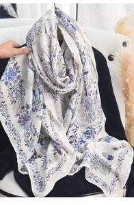 Detailed shot of thin lightweight scarf with ivory base and blue floral pattern print