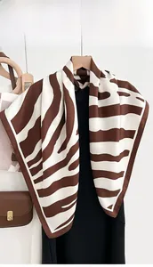 Detail of silk-like scarf with classic brown zebra print on a black dress