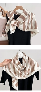 Close-up of elegant brown and beige striped silk scarf with a soft satin finish texture