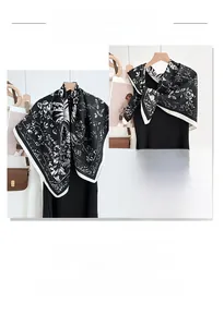 Detail of floral printed square scarf with black and white patterns on a clothes hanger