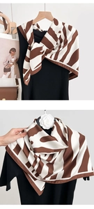 Detail of elegant animal print silk scarf in coffee and beige with satin finish