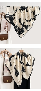 Détail d'un foulard en soie aux motifs floraux et feuilles d'érable noires sur beige