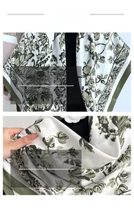 Detail of vintage floral print scarf with green borders and elegant botanical patterns