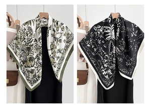 Close-up of elegant floral print square scarves in silk satin hanging on a model