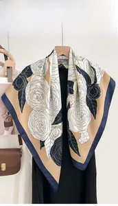 Close-up of vintage floral silk scarf with black rose patterns and navy blue edge