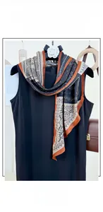 Detailed view of ethnic print scarf with orange geometric patterns and paisley designs