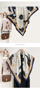 Detail view of a large floral silk scarf with chic navy blue borders and cream camellia print