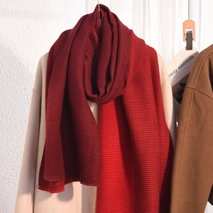 Winter chunky knit cashmere-feel scarf in deep red styled over a beige coat