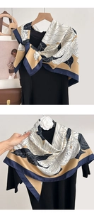 Detail of silk scarf showing rose floral print and navy blue hand-rolled edges