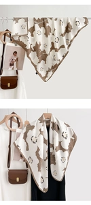 Détail d'un foulard en soie à imprimé floral avec drapé lisse et motifs marron