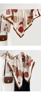 Detail of a large silk square scarf with vintage red camellia floral print and brown border