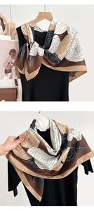 Detailed view of the elegant camellia print on this thin silk-feel scarf for women
