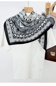 Detail of lightweight square scarf featuring retro paisley patterns in black and white