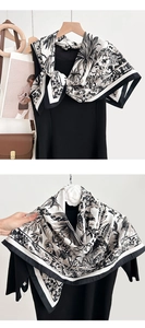 Detail of vintage floral print scarf draped as a shawl over a black dress and accessories