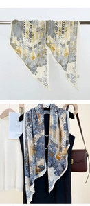 Détail d'un foulard en soie avec motifs architecturaux jaunes et feuilles de palmier