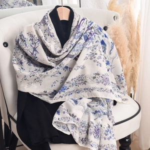 Lightweight white floral scarf with blue-purple flower and bird prints on a hanger