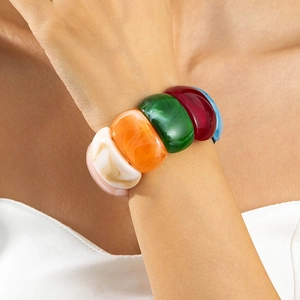 Close-up of a wide colorful acrylic block bracelet with retro chunky resin design on wrist