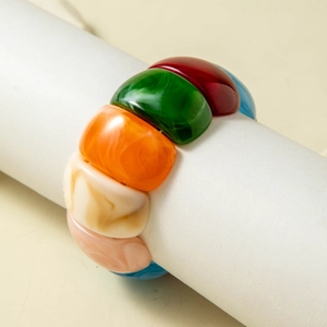 Macro shot of colorful resin bangle with marble textures and chunky geometric segments