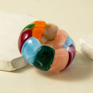 Macro shot of colorful resin stretch bracelet with marble texture on a white stone