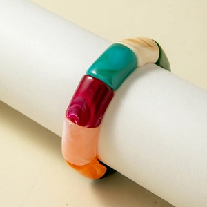 Close-up of colorful acrylic beaded stretch bracelet on a white display stand