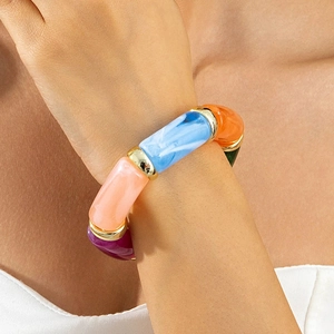 Close-up of colorful acrylic chunky bracelet with vibrant segments and gold metal rings