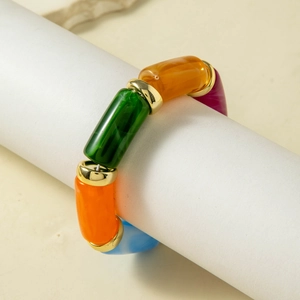 Detail of colorful acrylic beaded bracelet with golden metal caps on white display