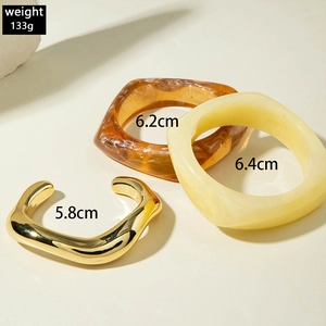 Three-piece chunky bracelet set with amber resin and gold wavy metal cuffs detail