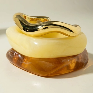 Chunky irregular resin and gold metal bangles in amber, cream, and wavy gold design