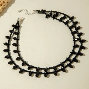 Detail of double-layer black beaded necklace with faceted beads and silver lobster clasp