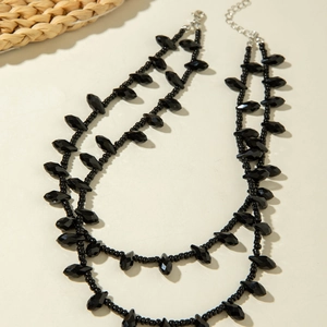 Detailed view of double-layer black beaded necklace with faceted charms and silver clasp