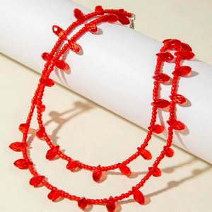Elegant red double-layer beaded necklace featuring faceted marquise beads on white podium