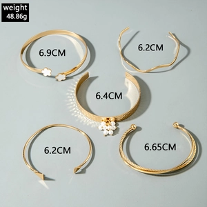Lot de cinq bracelets dorés multicouches avec trèfles, perles et fleurs en émail