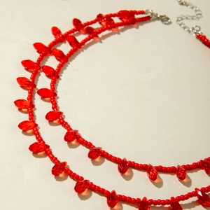 Detail of red double-layer beaded necklace featuring crystal waterdrop fringe and silver clasp